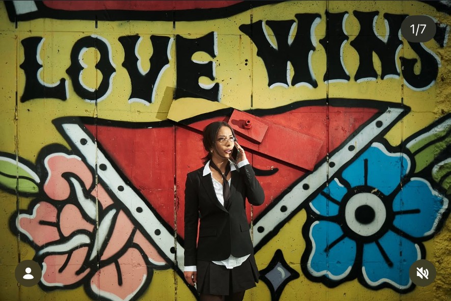 Sara Bic standing in front of the Love Wins mural during Mural Talks: Over It
