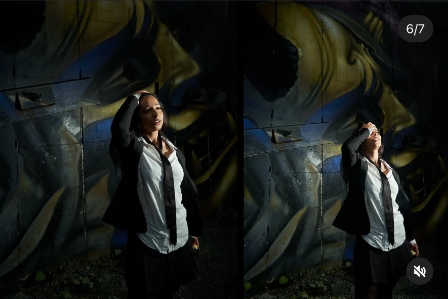 Sara Bic under low light with loose tie and backlit pose