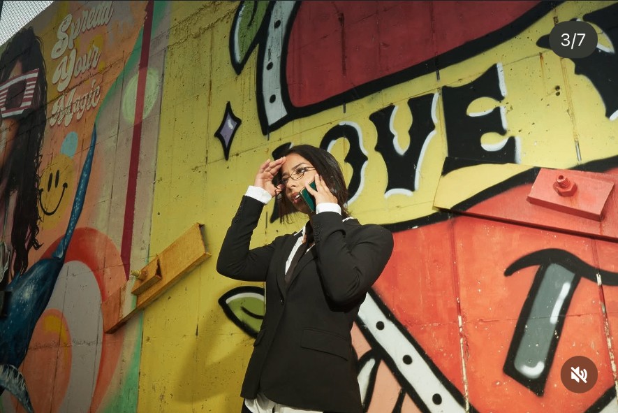 Sara Bic framed against the Love Wins wall with a phone pose